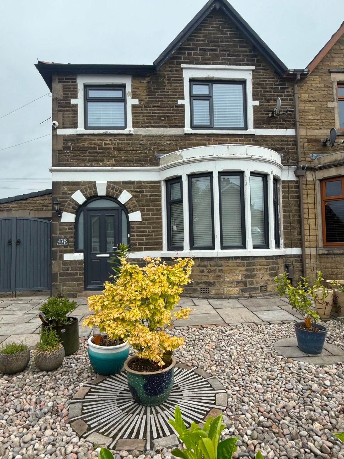 Cleaned stone semi-detached house with restored bay window and stone dressings