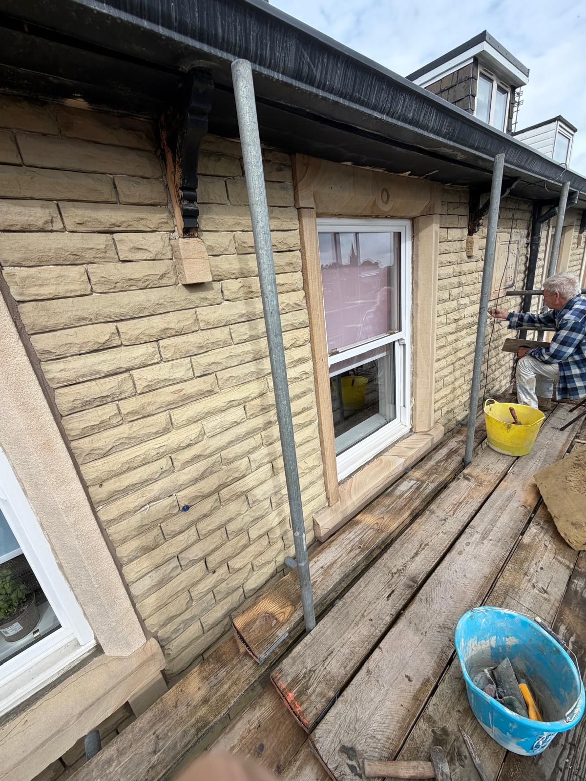 Operator working from scaffold on the stone frontage
